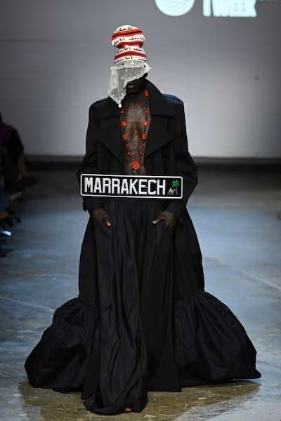 Black taffeta cape and lace ensemble with a Marrakech sign — Artsi Ifrach