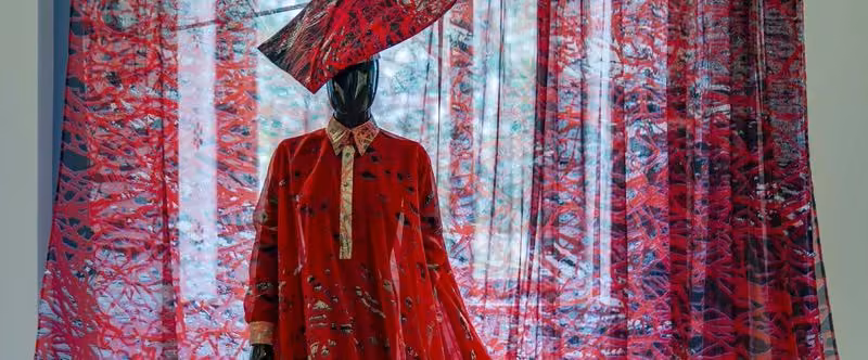 Printed textiles and red garment — exhibition installation — Martin Bergström
