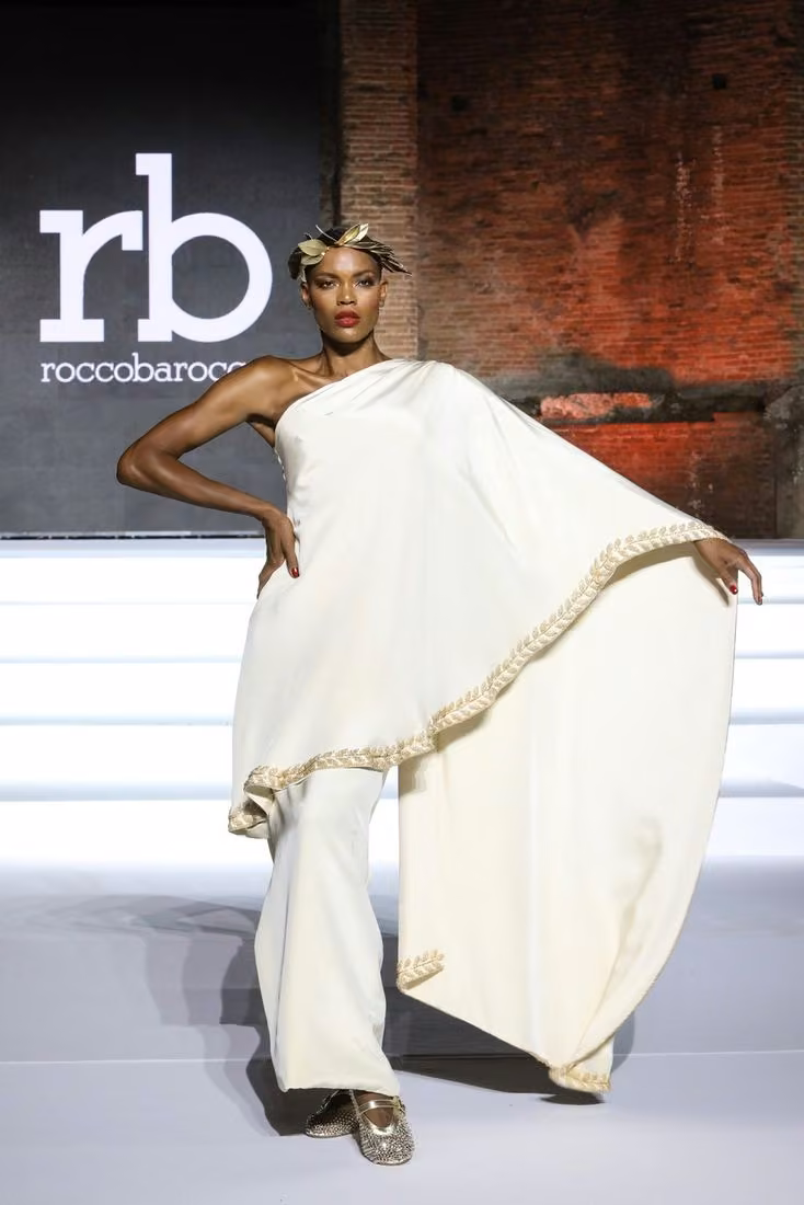 White one-shoulder draped ensemble with gold trim — Rocco Barocco