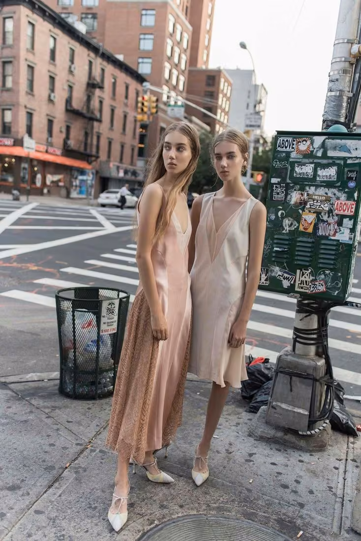 Pale draped dresses with asymmetric hems — Wes Gordon