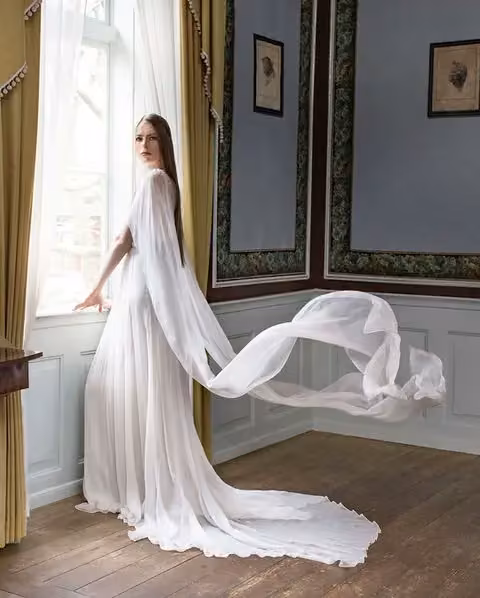 White gown with flowing cape sleeves — Leila Hafzi, Date not documented