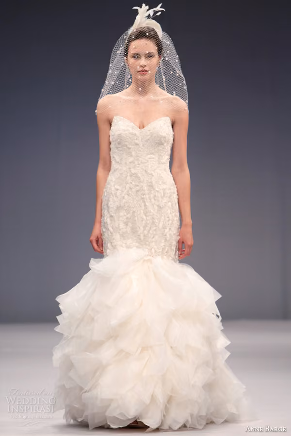 Runway model in the Angelique strapless lace mermaid gown with ruffled skirt.
