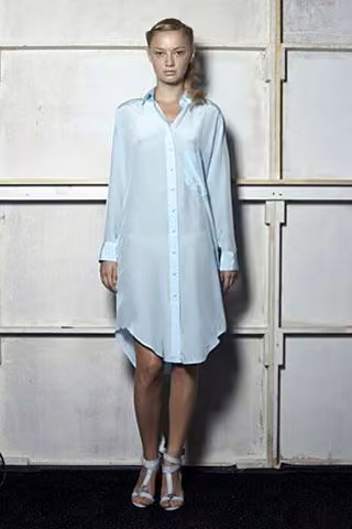 Model in a pale blue long-sleeved shirtdress.
