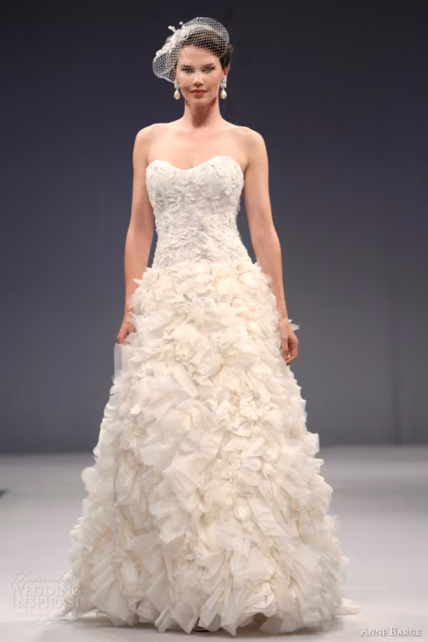 Runway model in the Capucine strapless gown with a textured petal-like skirt.
