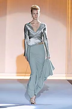 Runway model in a pale green wrapped top and flowing long skirt.