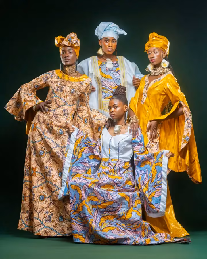 Patterned ceremonial dress — seated foreground model — Alphadi, 2026