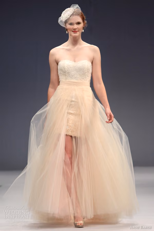 Runway model in the Sylvie short lace dress beneath a blush tulle overskirt.
