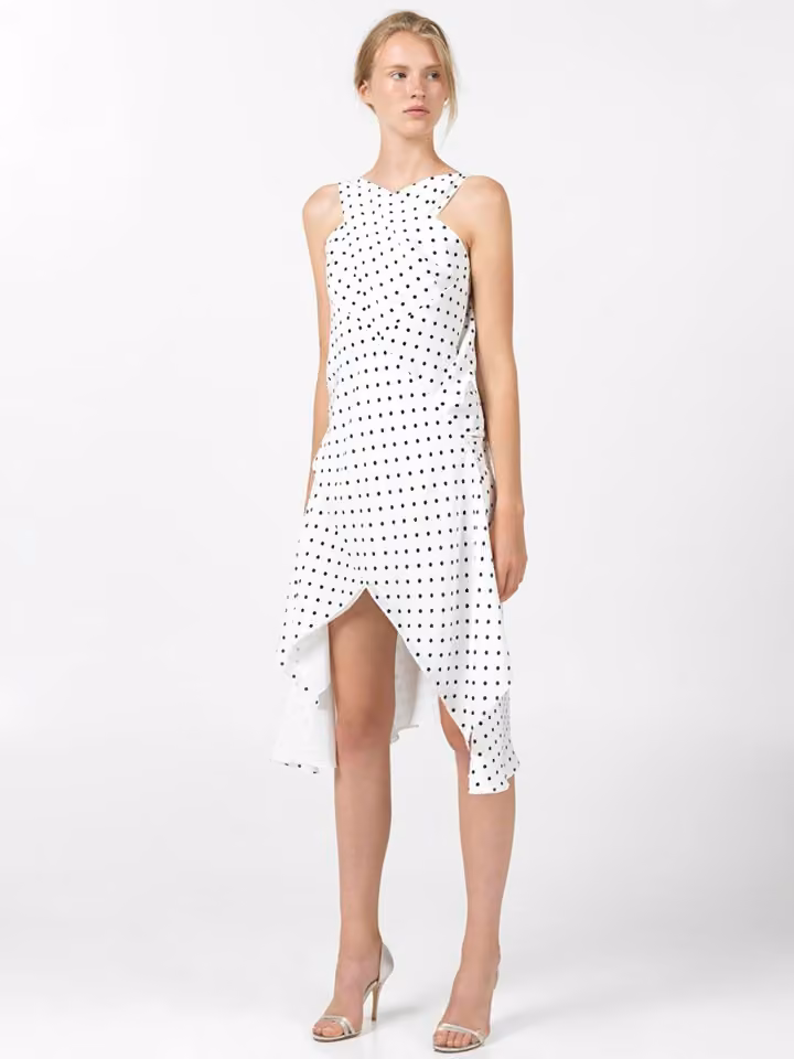 Model in a white dotted dress with an asymmetric hem.