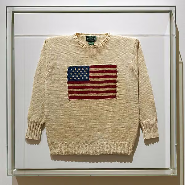 Cream ribbed crewneck sweater with an American flag knitted across the front.